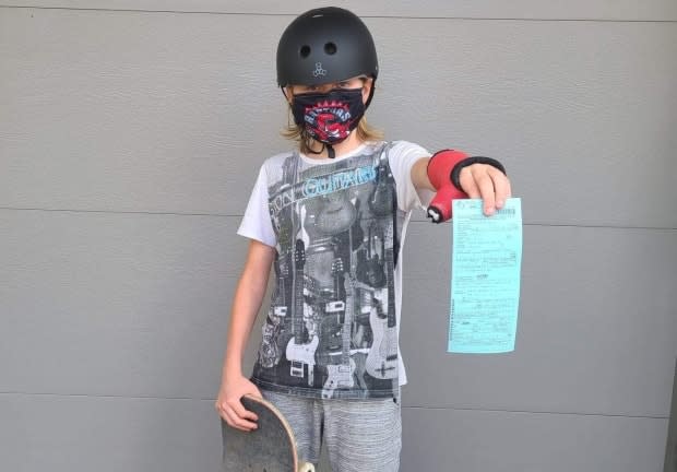 Merrick Batstone, 14, shows the $880 ticket handed to his family days after he visited Legacy Skatepark. (Submitted by Michelle Opthof - image credit)
