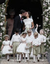 <p>As the newlyweds share a kiss, the children scatter confetti. (Photo: PA) </p>