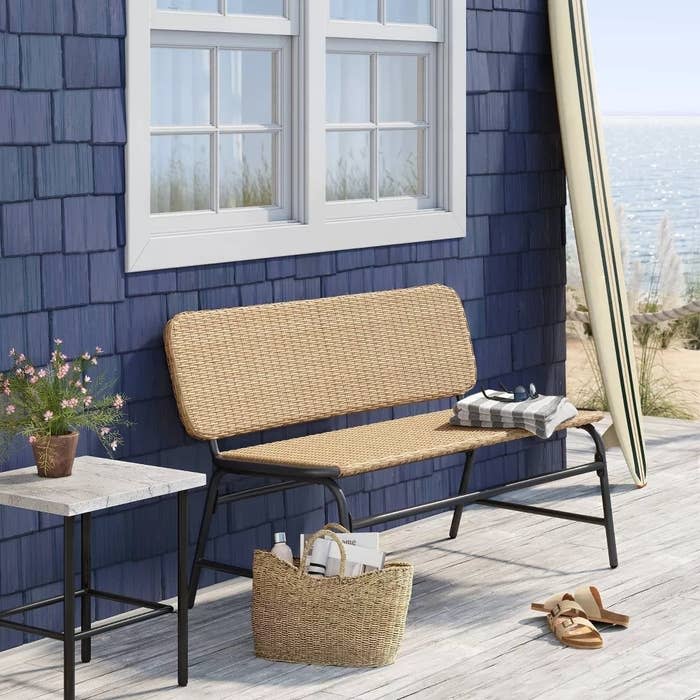 Outdoor bench with wicker backrest and a metal frame