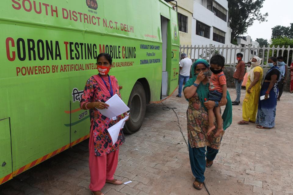 People wait to be tested outside a mobile COVID-19 coronavirus testing vehicle in New Delhi on August 10, 2020. (Photo by Prakash SINGH / AFP) (Photo by PRAKASH SINGH/AFP via Getty Images)