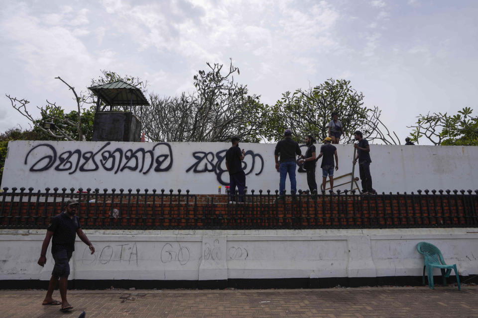 Protesters write "Open for Public" on the front wall of prime minister's official residence a day after it was stormed in Colombo, Sri Lanka, Sunday, July 10, 2022. Sri Lanka’s president and prime minister agreed to resign Saturday after the country’s most chaotic day in months of political turmoil, with protesters storming both officials’ homes and setting fire to one of the buildings in a rage over the nation's severe economic crisis.(AP Photo/Eranga Jayawardena)