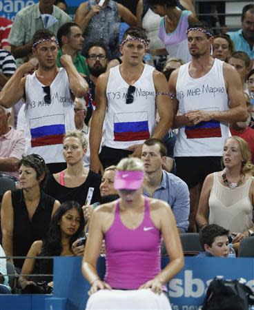 Supporters of Russia's Maria Sharapova are pictured behind her in between games during her womens' singles semi-final loss to Serena Williams of the U.S. at the Brisbane International tennis tournament in Brisbane, January 3, 2014. REUTERS/Jason Reed