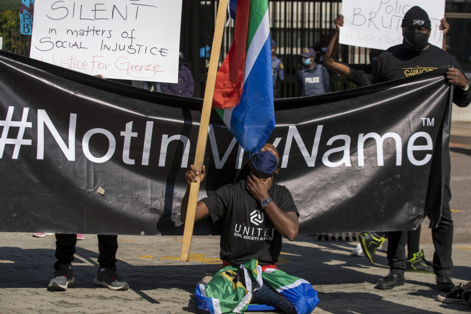 A man screams "I can't breath" whilst holding his neck during a protest against racism in front of the U.S. Embassy in Pretoria, South Africa, Friday, June 5, 2020. Chanting "black lives matter" and kneeling silently protesters read aloud the names of victims of police brutality, including that of George Floyd, a black American man who died being restrained by Minneapolis police officers on May 25. (AP Photo/Themba Hadebe)