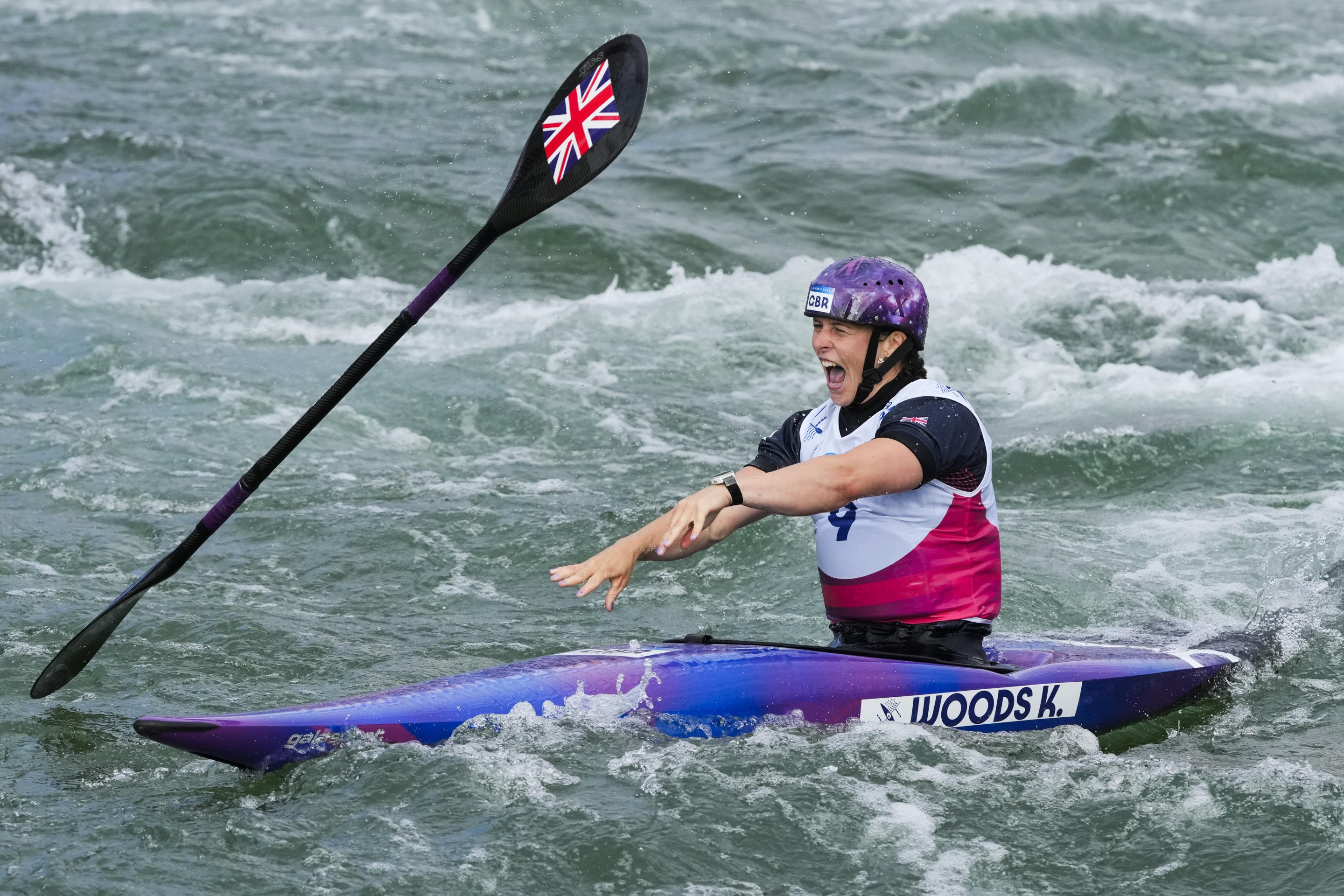 Kimberley Woods of Britain on the water reacts with her paddle after competing in women's kayak single finals during the canoe slalom in Vaires-sur-Marne.