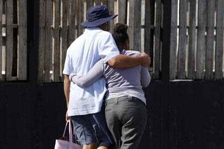 Navy Yard workers evacuated after the shooting are reunited with loved ones at a makeshift Red Cross shelter at the Nationals Park baseball stadium near the affected naval installation in Washington, September 16, 2013. REUTERS/Jonathan Ernst