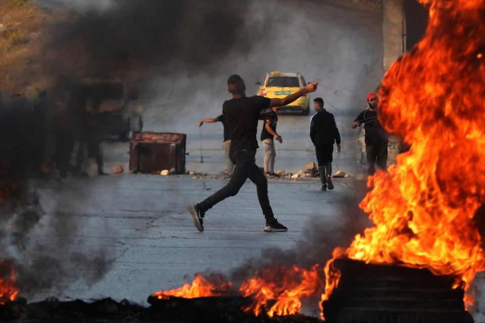 Manifestante palestino arroja piedras a los soldados israelíes en confrontaciones ocurridas el domingo en la ciudad de Ramala, en la Cisjordania ocupada. (AFP a través de Getty Images)