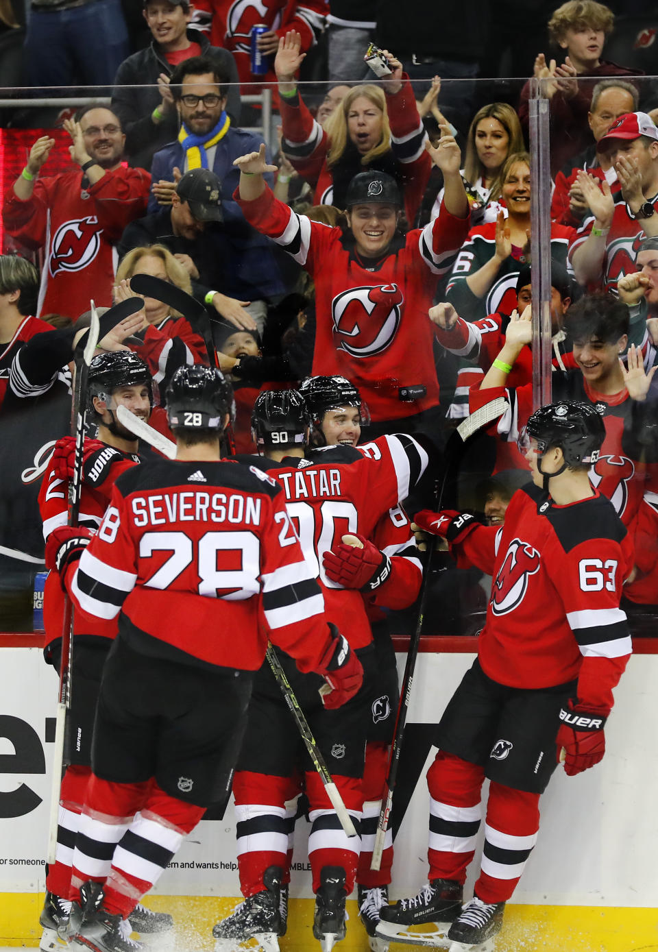 New Jersey Devils center Jack Hughes celebrates with left wing Tomas Tatar (90) after scoring a goal against the Arizona Coyotes during the first period of an NHL hockey game, Saturday, Nov. 12, 2022, in Newark, N.J. (AP Photo/Noah K. Murray)