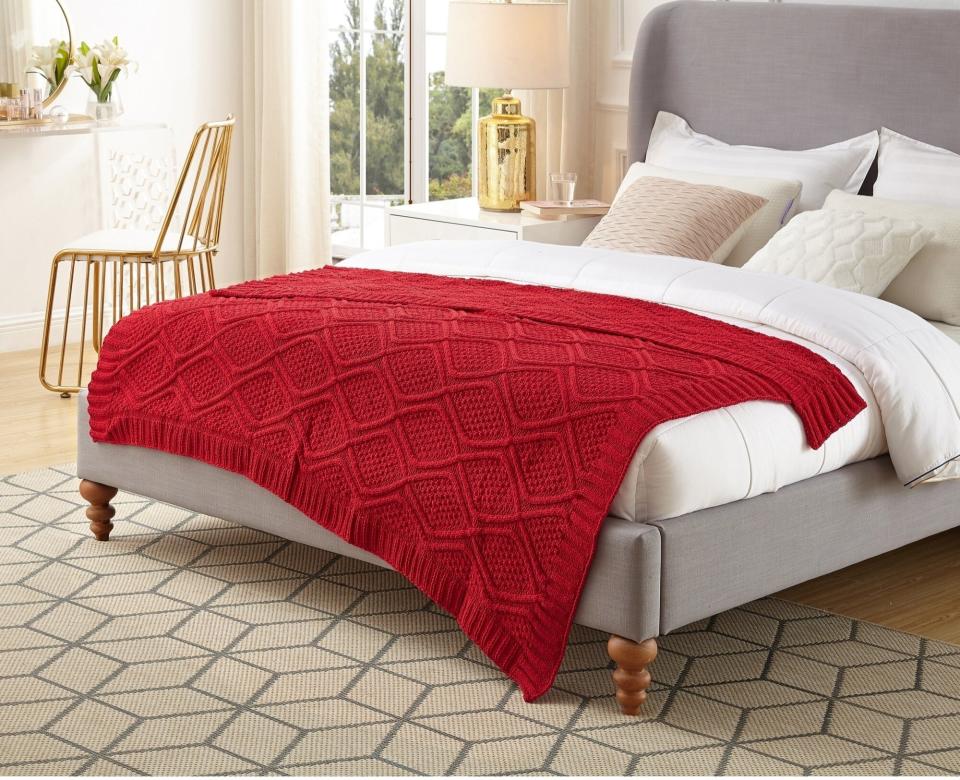 A knitted throw blanket on a bed