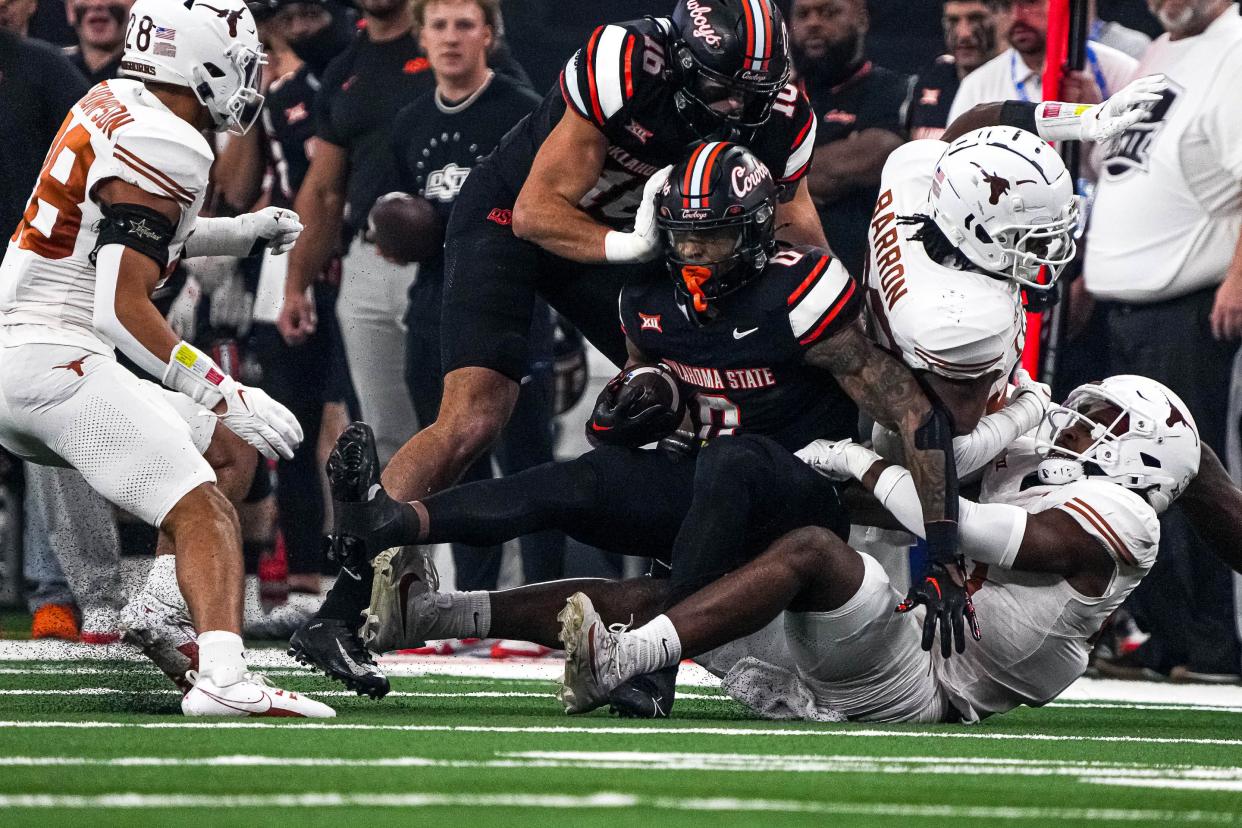 Oklahoma State running back Ollie Gordon II (0) is tackled during the Big 12 Championship game against the Texas Longhorns at AT&T stadium on Saturday, Dec. 2, 2023 in Arlington.