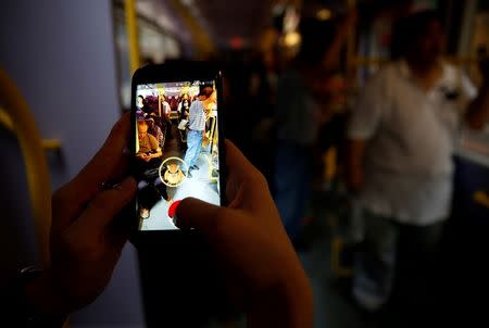 A passenger plays the augmented reality mobile game "Pokemon Go" by Nintendo inside a bus in Hong Kong, China August 12, 2016. REUTERS/Tyrone Siu