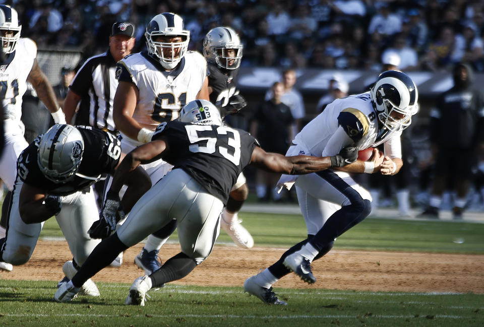 Los Angeles Rams quarterback Brandon Allen, right, evades a tackle by Oakland Raiders' Jason Cabinda (53) during the first half of a preseason NFL football game Saturday, Aug. 10, 2019, in Oakland, Calif. (AP Photo/Rich Pedroncelli)