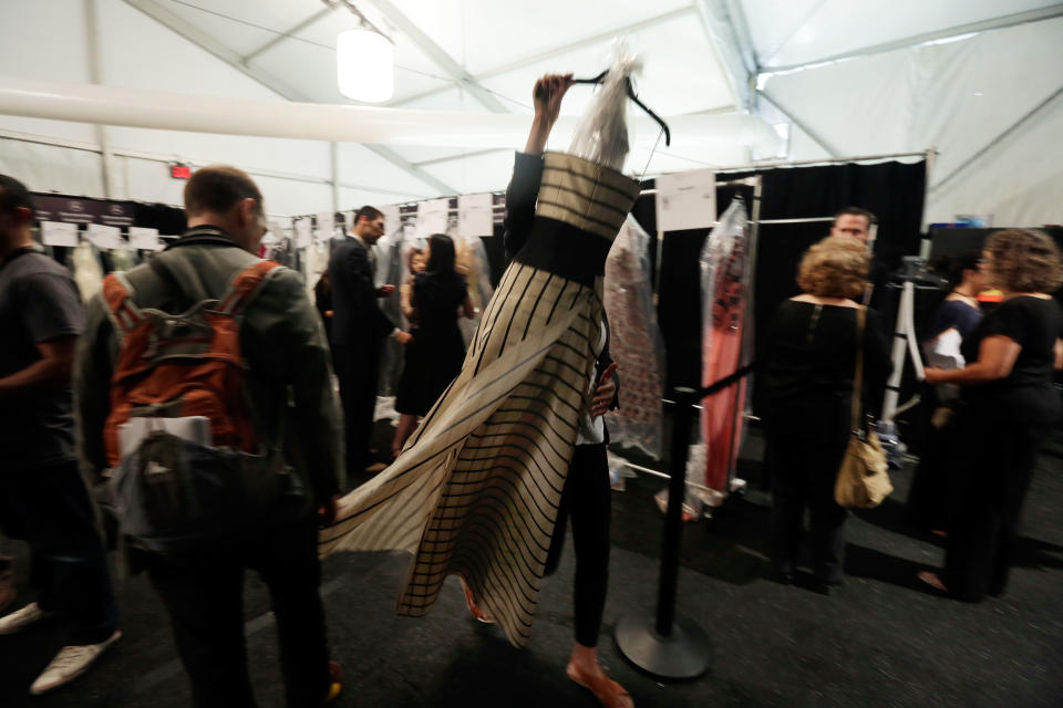 A dress from the Carolina Herrera Spring 2014 collection is carried backstage during Fashion Week in New York, Monday, Sept. 9, 2013. (AP Photo/Richard Drew)