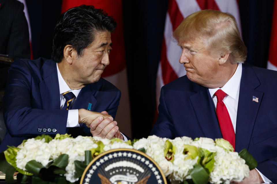 FILE - U.S. President Donald Trump, right, shakes hands with Japanese Prime Minister Shinzo Abe before signing an agreement on trade at the InterContinental Barclay New York hotel during the United Nations General Assembly, in New York on Sept. 25, 2019. During 2014-2020, Abe served two additional terms as prime minister for a total of four, during which he develops close relations with then-president Donald Trump, holding summits and golfing together. (AP Photo/Evan Vucci, File)