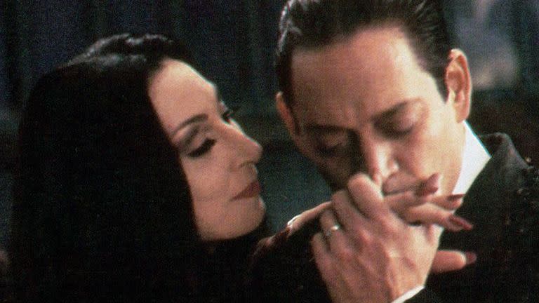 gomez gives morticia a kiss on the hand in a scene from the addams family a good housekeeping pick for best halloween movies