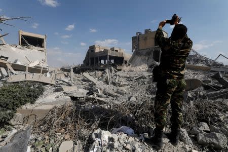 Un militar graba un vídeo de un centro de investigación científica de Damasco destruido por ataques liderados por Estados Unidos. 14 de abril de 2018. REUTERS/Omar Sanadiki