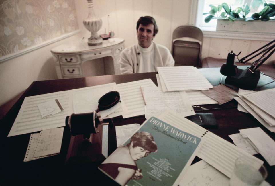 Burt Bacharach at a piano with papers all over it