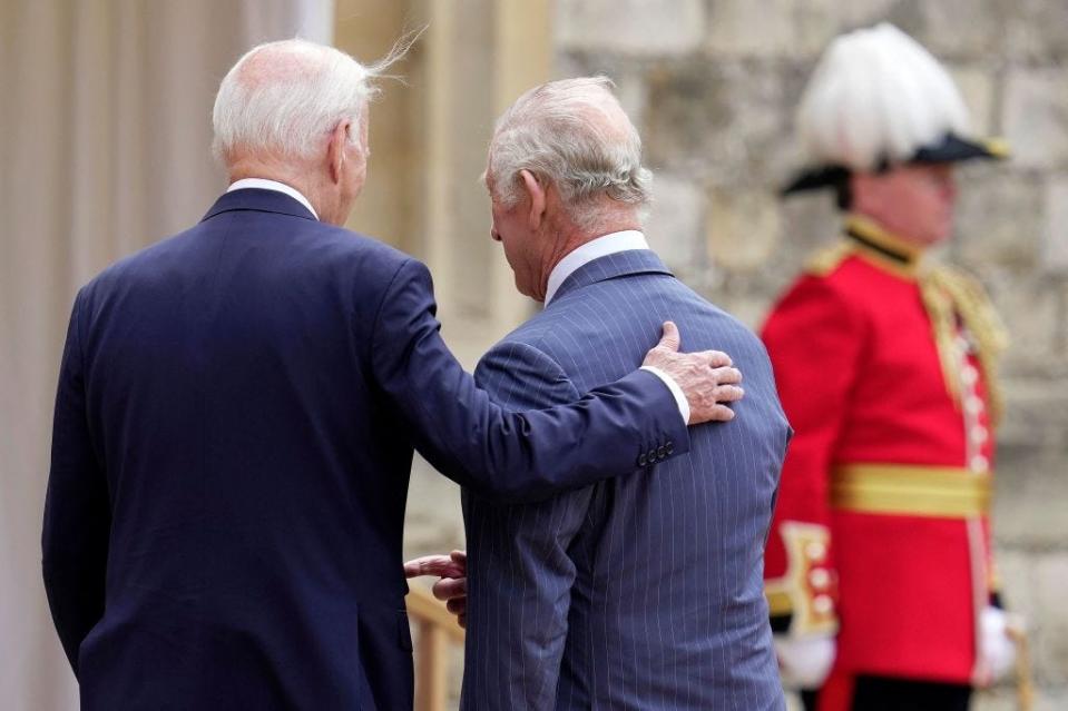 President Joe Biden places his hand on King Charles' back in 2023.