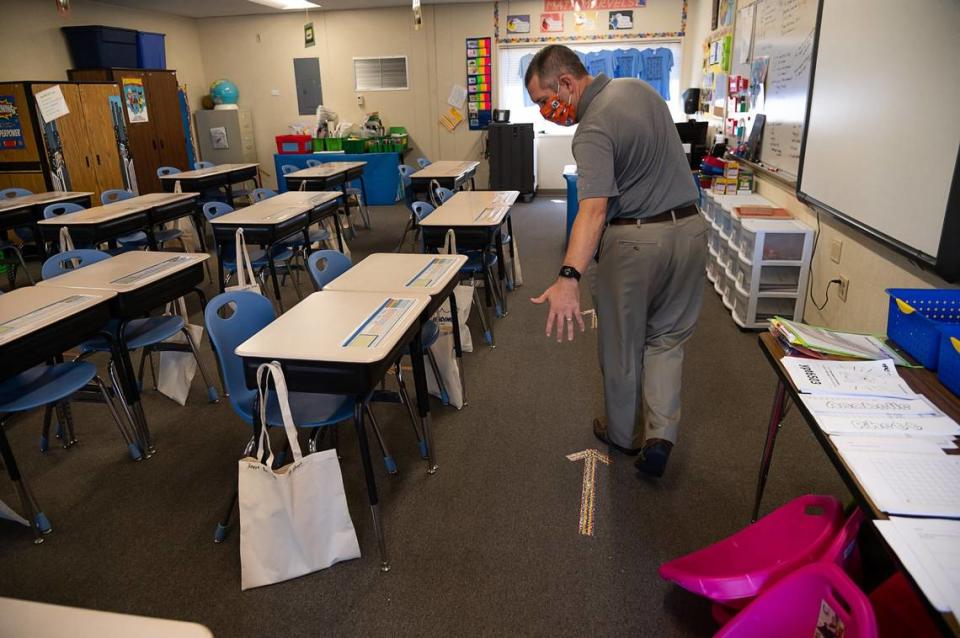 Principal Dustin Haley shows arrows on the floor to help third-grade students to socially distance in their classroom at Rescue Elementary School on Wednesday, Aug. 12, 2020 in Rescue. The school will reopen to students on Monday.