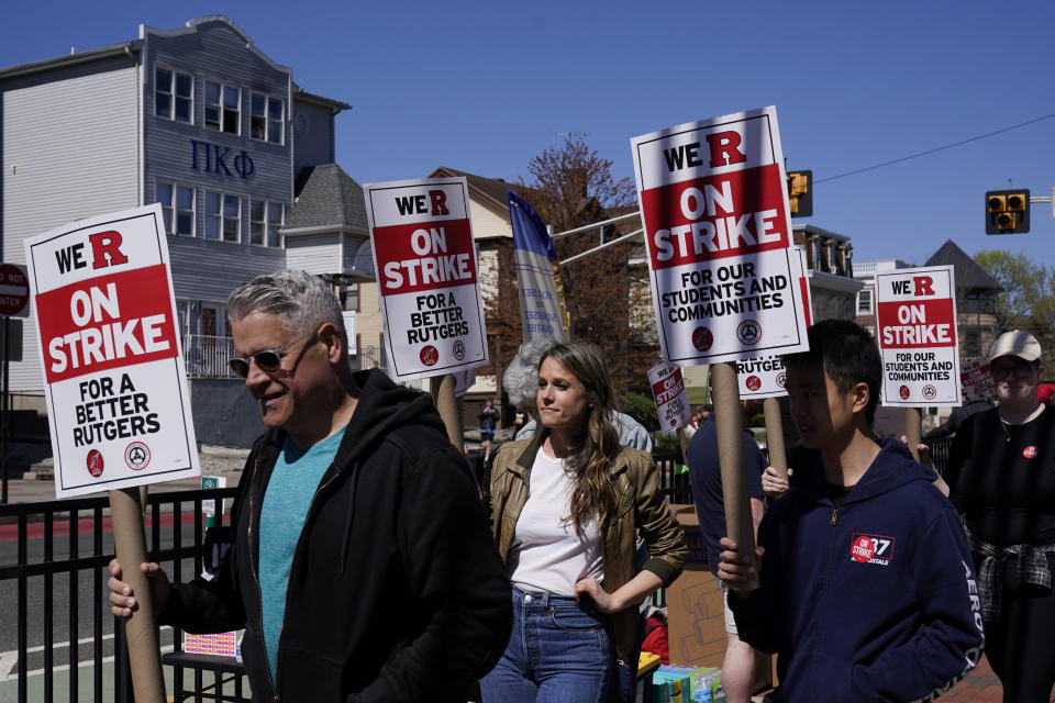 Strikers march in front of Rutgers' buildings in New Brunswick, N.J., Monday, April 10, 2023. Thousands of professors, part-time lecturers and graduate student workers at New Jersey's flagship university have gone on strike — the first such job action in the school's 257-year history. (AP Photo/Seth Wenig)