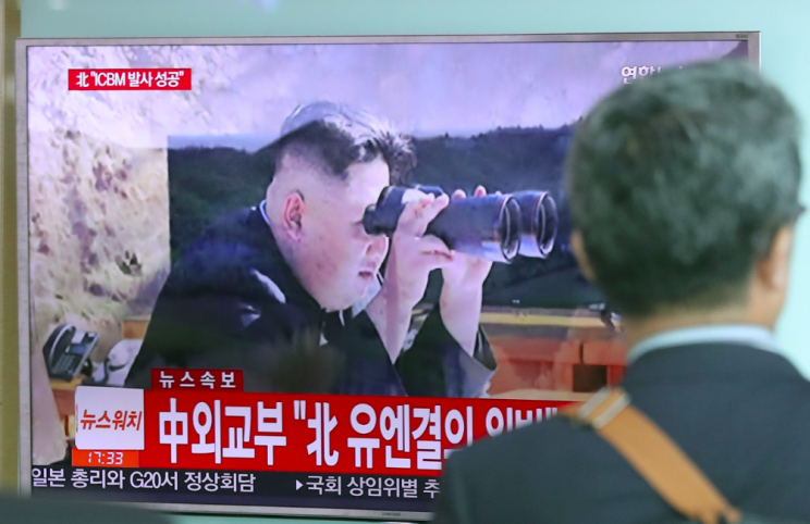 Kim Jong-un pictured on a TV screen in Seoul, South Korea, in a news report about the missile test (Picture: Rex)