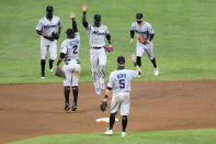 Miami Marlins players engage in a social distant celebration after defeating the Baltimore Orioles 4-0 during a baseball game, Tuesday, Aug. 4, 2020, in Baltimore. (AP Photo/Julio Cortez)