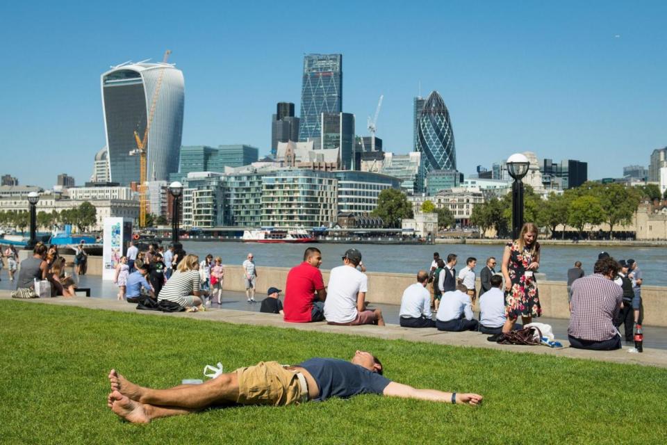 A man lies in the sun in Potter's Field Park in central London (PA Archive/PA Images)