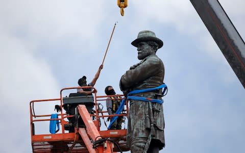 Workers prepare to take down the statue of former Confederate Gen. Robert E. Lee, which stands over 100 feet tall, in Lee Circle in New Orleans - Credit: AP