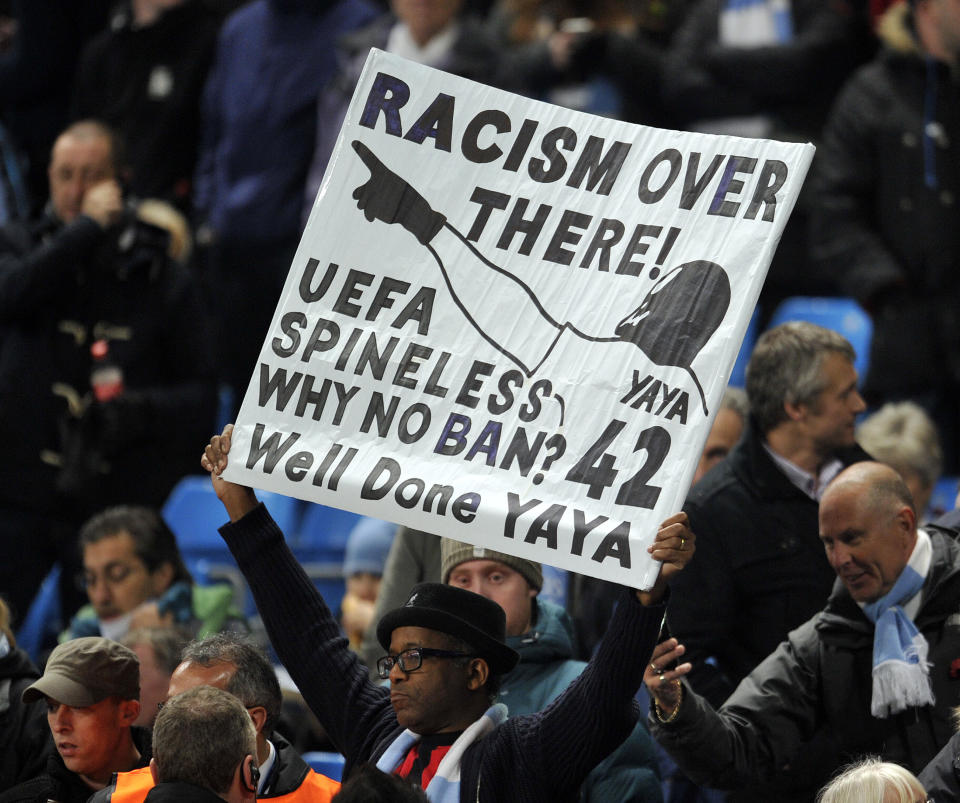 FILE - A Manchester City fan holds an anti-racism banner in the stands during the Champions League Group D soccer match between Manchester City and CSKA Moscow at the Etihad Stadium in Manchester, Britain, Tuesday, Nov. 5, 2013. The manifestation of a deeper societal problem, racism is a decades-old issue in soccer — predominantly in Europe but seen all around the world — that has been amplified by the reach of social media and a growing willingness for people to call it out. (AP Photo/Clint Hughes, File)