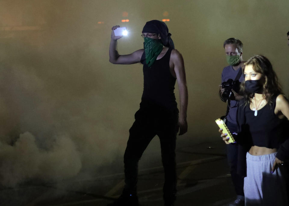 Aug 23, 2020; Kenosha, WI, USA; A man records cellphone video as tear gas is used on protesters outside the Kenosha Police Department in Kenosha on Sunday, Aug. 23, 2020. Mandatory Credit: Mike De Sisti/Milwaukee Journal Sentinel via USA TODAY NETWORK/Sipa USA