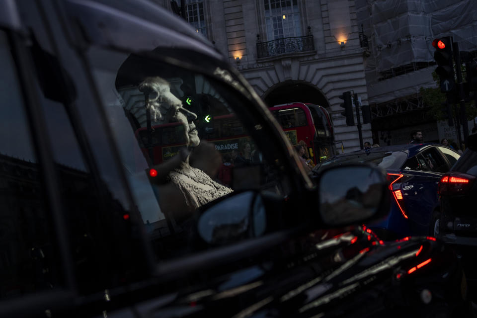 Un homenaje a la reina Isabel II se refleja en la ventana de un taxi en Piccadilly Circus en Londres, el 9 de septiembre de 2022, al día siguiente de que muriera a los 96 años. (AP Foto/Bernat Armangue)