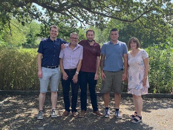 Andrew, his wife Rachel, and their sons, Jack, Charlie and Joshua in front of a tree