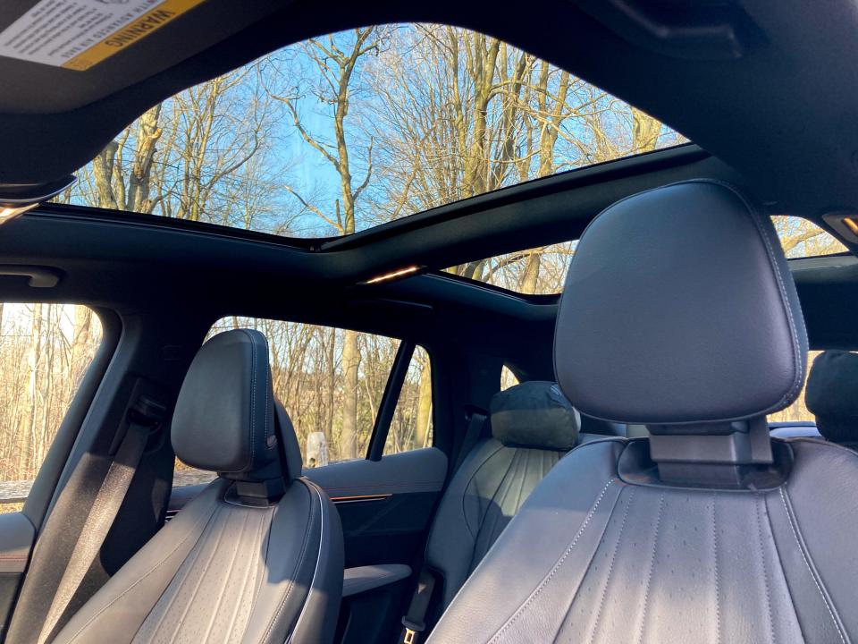 The front seats of the 2023 Mercedes-Benz EQS SUV with a glass sunroof in the background.
