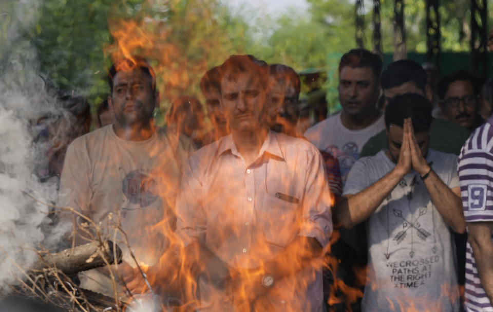 Relatives and friends attend the cremation of Rahul Bhat, a government employee killed on Thursday, in Jammu, India, Friday, May 13, 2022. Bhat, who was a minority Kashmiri Hindu known as "pandits," was killed by suspected rebels inside his office in Chadoora town in the Indian portion of Kashmir. (AP Photo/Channi Anand)