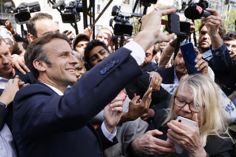 El presidente franc&#xe9;s y candidato Emmanuel Macron se toma una selfie con residentes durante una escala de campa&#xf1;a el jueves 21 de abril de 2022 en Saint-Denis, en las afueras de Par&#xed;s. (Ludovic Marin, Pool v&#xed;a AP)