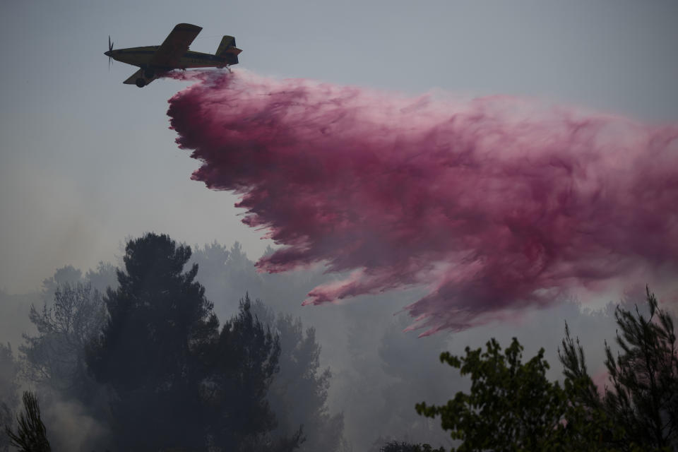 ARCHIVO - Un avión lanza un retardante de fuego para extinguir las llamas en un área cerca de la frontera con el Líbano, en Safed, en el norte de Israel, el miércoles 12 de junio de 2024. (AP Foto/Leo Correa, archivo)