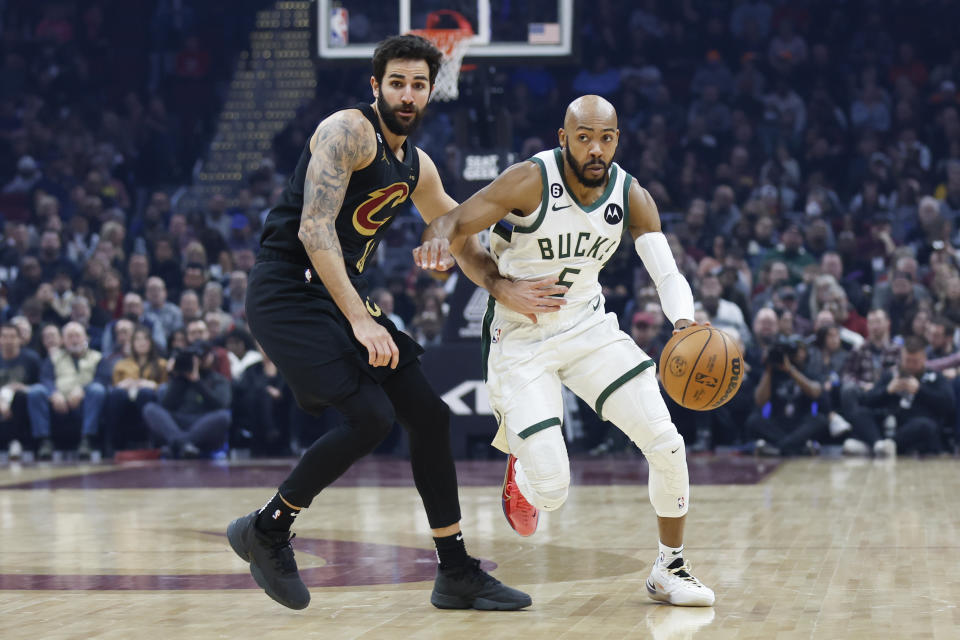 Milwaukee Bucks guard Jevon Carter (5) drives against Cleveland Cavaliers guard Ricky Rubio during the first half of an NBA basketball game, Saturday, Jan. 21, 2023, in Cleveland. (AP Photo/Ron Schwane)