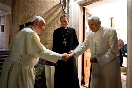 Pope Francis (L) shakes hands with Pope Emeritus Benedict XVI at the Mater Ecclesiae monastery at the Vatican, December 23, 2013. REUTERS/Osservatore Romano