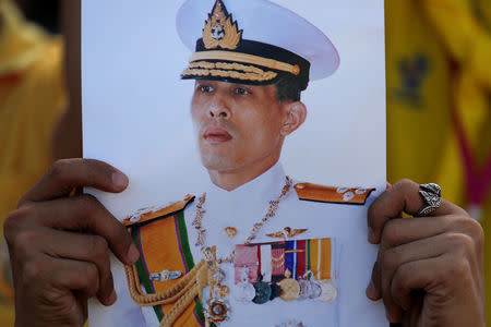 A member of public holds an image of King Maha Vajiralongkorn during his coronation in Bangkok, Thailand, May 4, 2019. REUTERS/Navesh Chitrakar