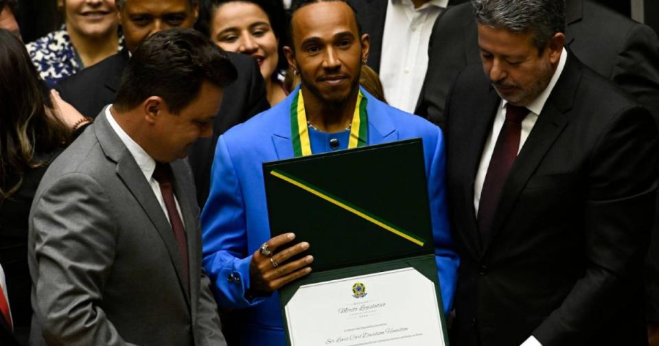 Lewis Hamilton holding Brazilian citizenship diploma. Brasilia November 2022. Credit: Alamy