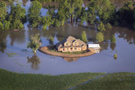 VICKSBURG, MS - MAY 18: A levee protects a home surrounded by floodwater from the Yazoo River May 18, 2011 near Vicksburg, Mississippi. The flooded Mississippi River is forcing the Yazoo River to top its banks where the two meet near Vicksburg causing towns and farms upstream on the Yazoo to flood. The Mississippi River at Vicksburg is expected to crest May 19. Heavy rains have left the ground saturated, rivers swollen, and have caused widespread flooding along the Mississippi River from Illinois to Louisiana. (Photo by Scott Olson/Getty Images)