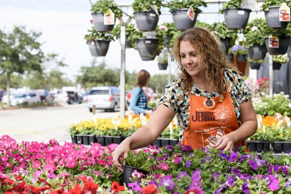 A Home Depot garden department employee works with plants