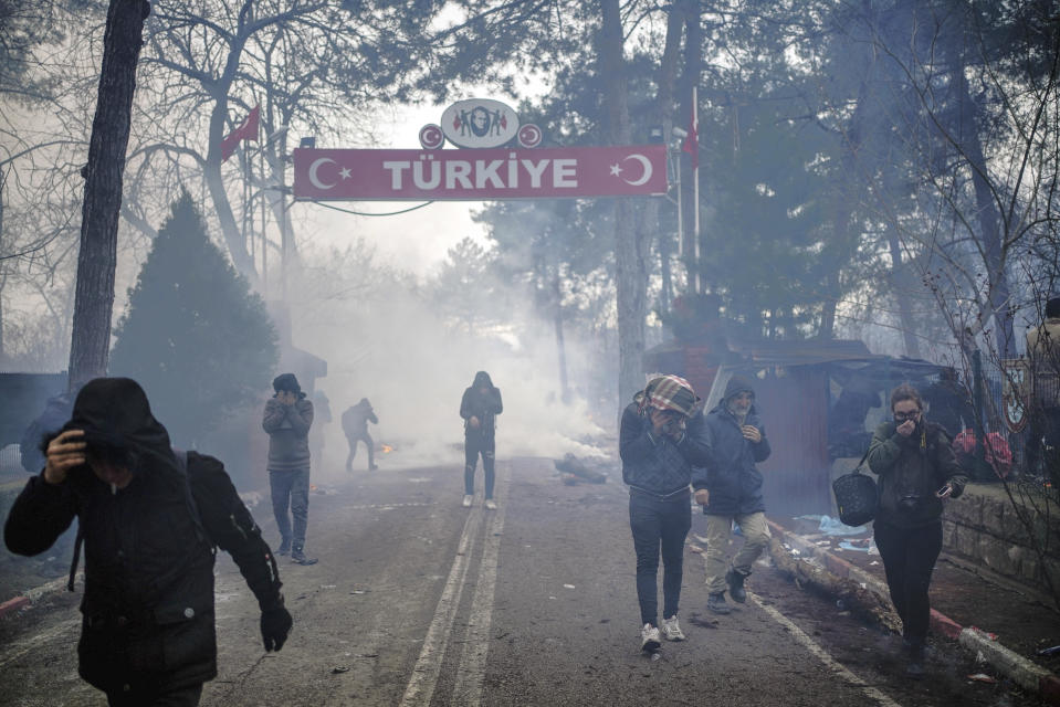 Agentes fronterizos griegos lanzan gases lacrimógenos para dispersar a los migrantes que intentaban cruzar a Grecia por el paso fronterizo de Pazarkule, en Edirne, Turquía, el 29 de febrero de 2020. (Ismail Coskun/IHA via AP)