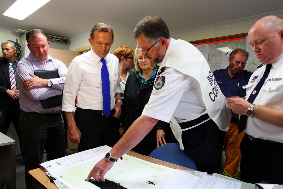 Prime Minister Tony Abbott attends a bushfire briefing with federal member for Macquarie Louise Markus, RFS incident controller David Jones and RFS Commissioner Shane Fitzsimmons on October 18, 2013 in Winmalee, Australia. (Photo by Lisa Maree Williams/Getty Images)