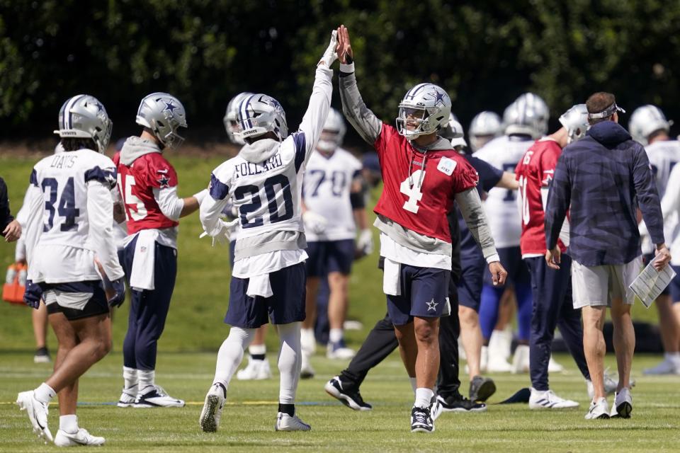 Dallas Cowboys running back Tony Pollard (20) and quarterback Dak Prescott (4) greet each other during a practice at the NFL football team's training facility in Frisco, Texas, Wednesday, Oct. 12, 2022. (AP Photo/Tony Gutierrez)