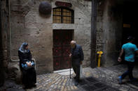 FILE PHOTO: People pass by the seventh station of the cross on Via Dolorosa, or the Way of the Cross, believed by Christians to be the route Jesus Christ carried his cross to his crucifixion, in Jerusalem's Old City May 20, 2014. REUTERS/Finbarr O'Reilly/File Photo