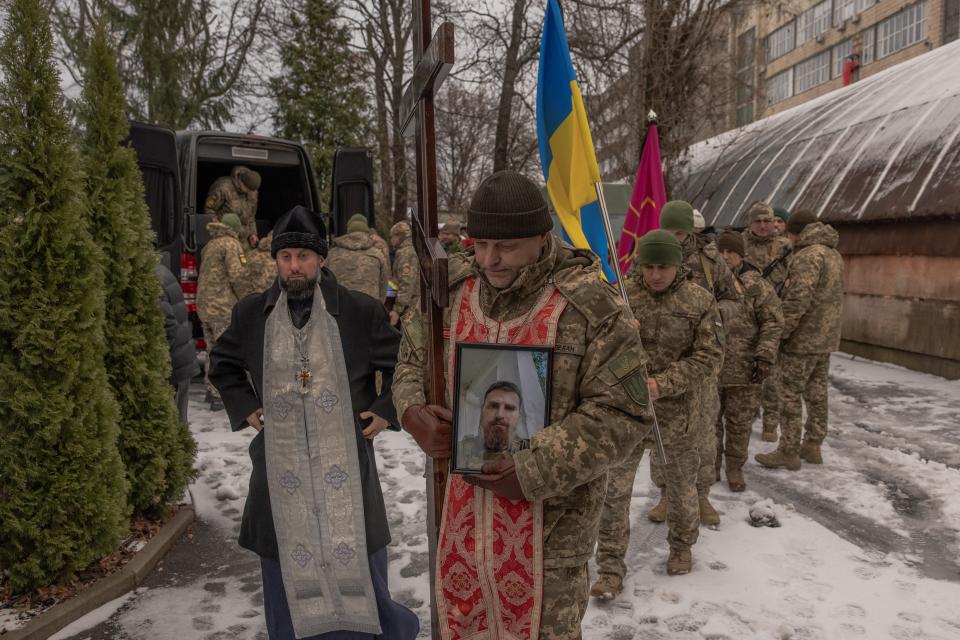 A Ukrainian serviceman holds the portrait of Ukrainian serviceman Sergiy Pavlichenko, who was killed fighting Russian troops (AFP via Getty Images)