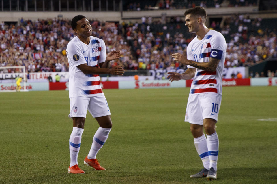 FILE - United States' Weston Mckennie, left, and Christian Pulisic celebrate after Mckennie's goal during the first half of a CONCACAF Gold Cup soccer match against Curacao, Sunday, June 30, 2019, in Philadelphia. The United States won 1-0. Having revived their careers in Italy, AC Milan's Christian Pulisic and Juventus' Weston McKennie are looking forward to facing each other later this month in Serie A before joining the U.S. national team for the Copa América. (AP Photo/Matt Slocum, File)