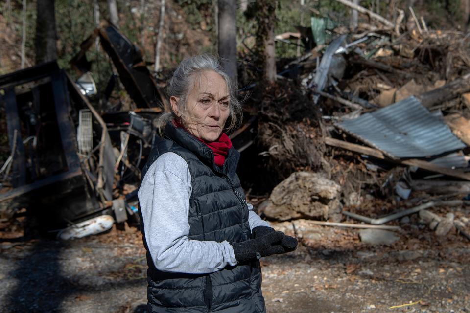 Sherri McArthur cries as she looks out at debris left by her beloved campers at Laurel Bank Campground along the Pigeon River December 22, 2021. "It's affected me so much. I lost four of my favorites ... I still cry," said McArthur, "I still cry every day when I think about it."