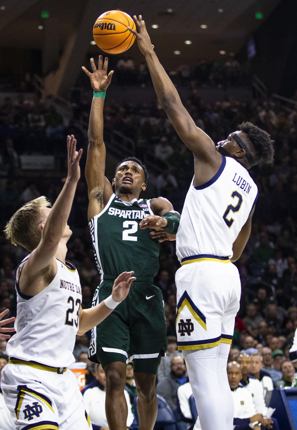 Michigan State's Tyson Walker, middle, is fouled by Notre Dame's Ven-Allen Lubin, right, during the first half of an NCAA college basketball game Wednesday, Nov. 30, 2022, in South Bend, Ind. (AP Photo/Michael Caterina)