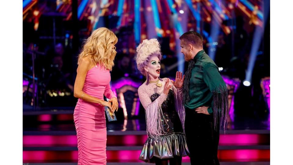 two dancers on dance floor chatting to host